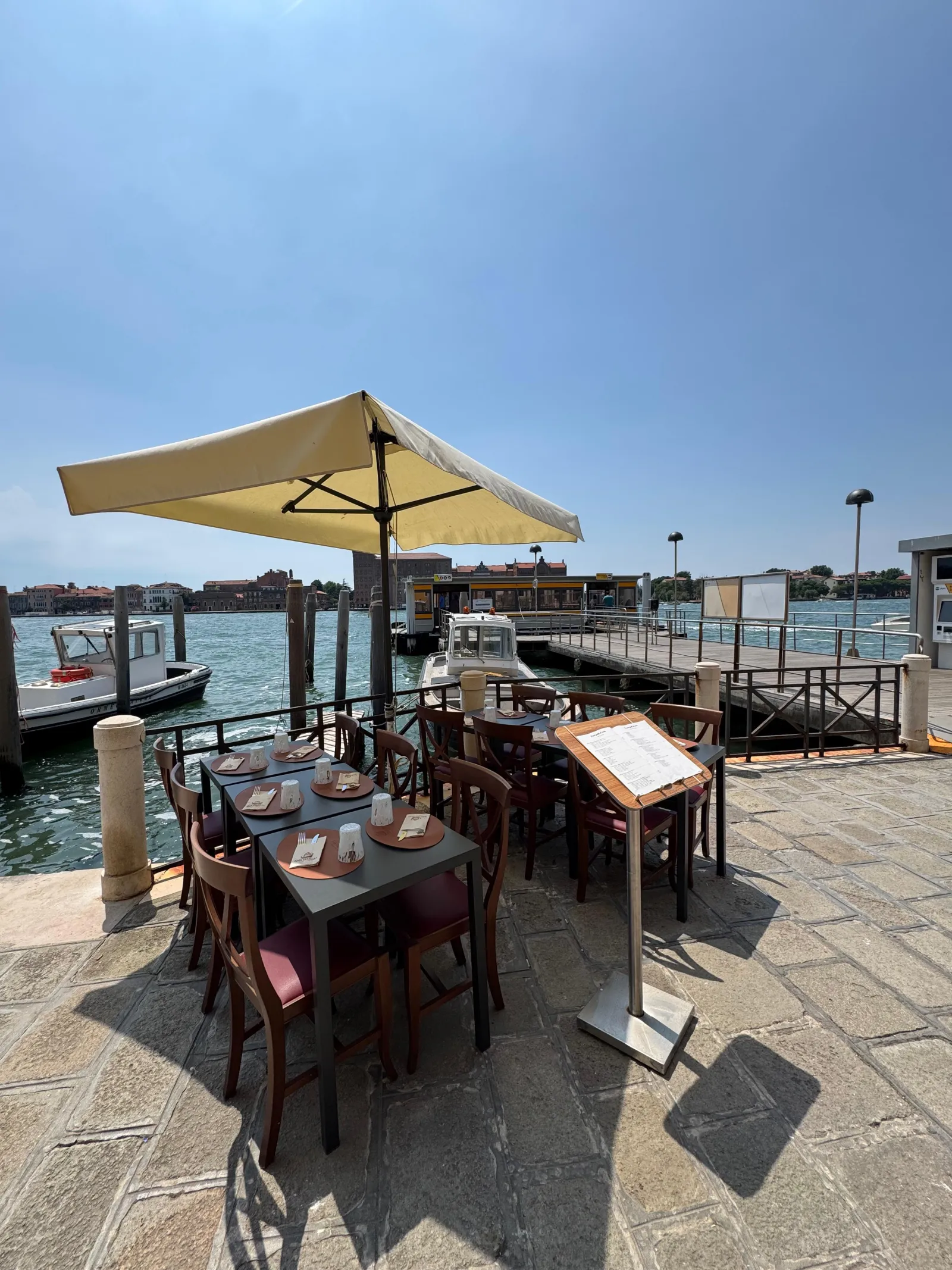 Parasol terrace on the San Basilio waterfront, sunny canal-side tables