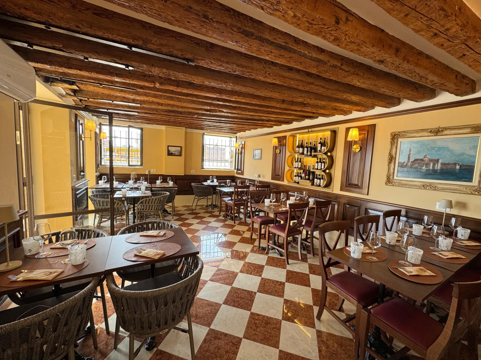 Dining room of Trattoria San Basilio opening onto the canal and the mooring posts